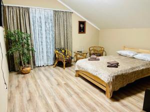 a bedroom with a large bed and a table at Капрі in Mukacheve +8 photos