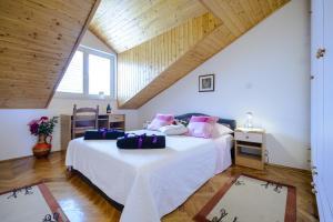 a bedroom with two beds with white sheets and pink pillows at Apartment Matic in Dubrovnik