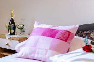 a bed with a pink and white pillow and wine glasses at Apartment Matic in Dubrovnik
