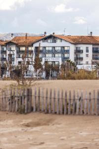 a building on the beach with a fence at Hôtel Serge Blanco - Relais Thalasso & Spa in Hendaye