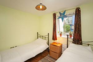 two twin beds in a room with a window at Special 3 Bedroom Townhouse With Parking in Bristol in Bristol
