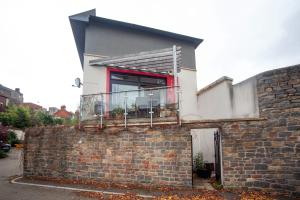 een huis met een balkon op een bakstenen muur bij Special 3 Bedroom Townhouse With Parking in Bristol in Bristol