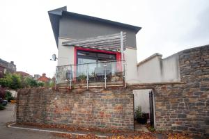 a house with a balcony on top of a brick wall at Special 3 Bedroom Townhouse With Parking in Bristol in Bristol
