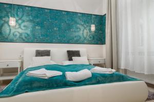 - une chambre avec un lit et une couverture bleue dans l'établissement P43 Paulay Apartment, à Budapest