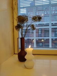a candle and a vase sitting next to a window at Hotelli Merikotka in Kotka