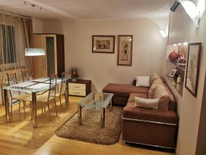a living room with a couch and a table at Uroczy apartament przy deptaku z parkingiem. in Polanica-Zdrój