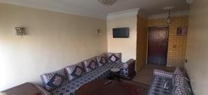 a living room with a couch with pillows at Maison de la famille in Casablanca