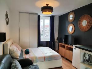 małą sypialnię z łóżkiem i telewizorem w obiekcie Studio design proche Défense-Paris w mieście Rueil-Malmaison