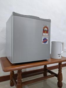a microwave oven sitting on a table with a coffee mug at Denai Senja in Kuala Selangor