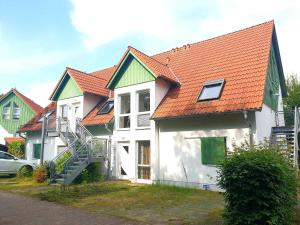 a group of houses with orange roofs and a car at Ferienwohnung Strandgold OLIV in Ostseebad Karlshagen