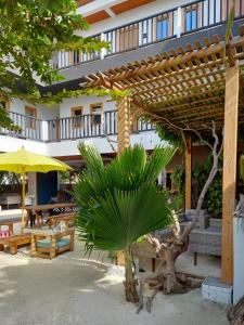 福拉杜島的住宿－Palms Retreat，一座建筑前的木凉亭和棕榈树