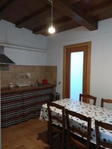 Casa Rural El Albergue في Beires: غرفة طعام مع طاولة ومطبخ