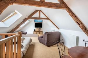 a room in the attic with a couch and a table at Le Grand Cancalais in Cancale