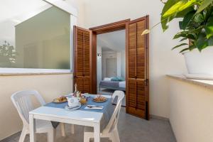 a dining room with a table and chairs and a bedroom at Samira in San Vito lo Capo