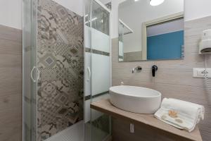 a bathroom with a sink and a glass shower at Samira in San Vito lo Capo