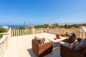 a patio with chairs and a table on a balcony at Villa Stone House in Neo Chorio