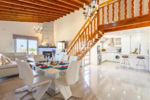 a dining room and living room with a table and chairs at Villa Stone House in Neo Chorio