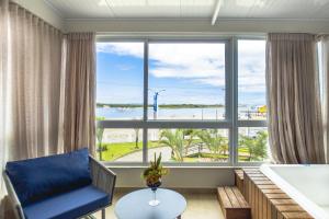 南巴尔内阿里奥Hotel Bandeirantes da Barra的客厅设有大窗户和浴缸。