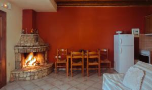 a kitchen with a fireplace and a table and chairs at Mezonetes Helmos in Áno Lousoí