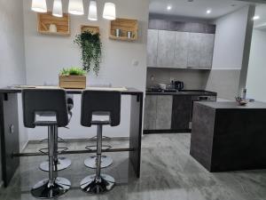 a kitchen with two bar stools and a counter at 306 APARTMAN in Subotica