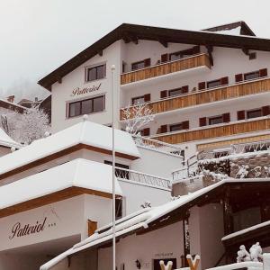 un edificio blanco con nieve encima en Patteriol Apart-Hotel-Garni en Sankt Anton am Arlberg