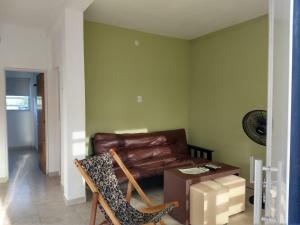 a living room with a leather couch and a table at Apart del YERUA in Puerto Yeruá