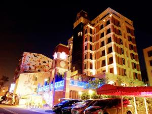 a large building with cars parked in front of it at night at F Hotel - Sanyi in Sanyi