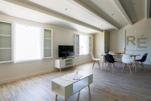 een grote woonkamer met een tafel en stoelen bij Appartement lumineux pour six personnes in Le Bois-Plage-en-Ré