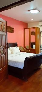 sypialnia z łóżkiem i czerwoną ścianą w obiekcie Your House 3 Guest House w mieście Chiang Mai
