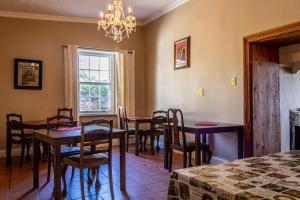 a dining room with tables and chairs and a chandelier at Sandstone Manor in Mossel Bay