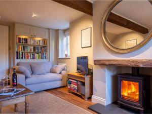 een woonkamer met een bank en een open haard bij Laurel Cottage in Cirencester