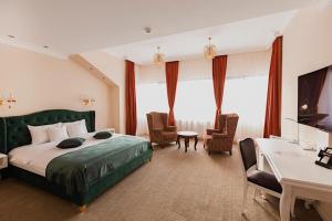 Cette chambre comprend un lit, un bureau et des chaises. dans l'établissement 4Cardinal's Hotel Boutique, à Braşov