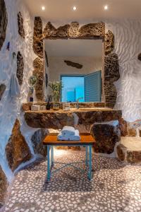 a stone bathroom with a sink and a mirror at Calilo in Manganari