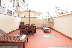 een balkon met een tafel en stoelen en een parasol bij AB Bailen Apartments in Barcelona