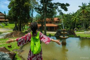 Una ragazza in piedi davanti a una fontana di Hotel Chalés Terra Nova a Itatiaia