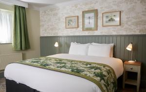 Habitación de hotel con 1 cama grande y 2 lámparas en Governors House by Greene King Inns en Cheadle Hulme