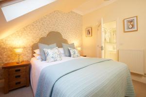 a bedroom with a large white bed with a window at Willowbeck Lodge Boutique Hotel in Carlisle