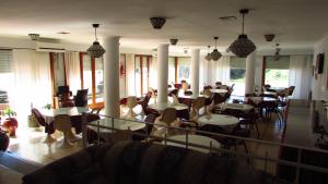 un comedor con mesas, sillas y ventanas en Hotel Stella Marina en San Clemente del Tuyú