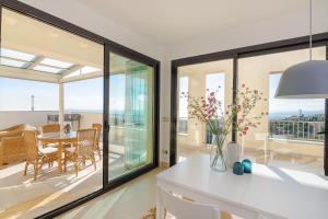 a kitchen with large windows and a dining room with a table at Luxurius Penthouse with Large Terrace and Spa in Marbella +28 photos