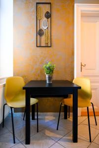 ウィーンにあるClassy Studio Naschmarktのダイニングルーム(黒いテーブル、黄色い椅子2脚付)