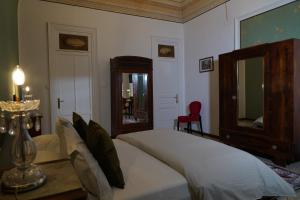 a bedroom with a large bed and a red chair at DS Apartments in Catania