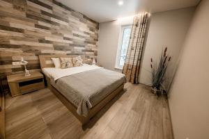 a bedroom with a bed and a wooden accent wall at Valsid puhkemaja in Alajõe