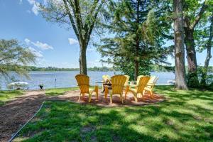 een groep stoelen rond een tafel aan het water bij White Pine Villa in Waterford