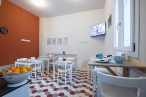 a dining room with tables and chairs and a bowl of fruit at Casa Livia in Pordenone