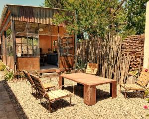 a patio with a wooden table and two chairs at LA FLORIDA - CASA PUEBLO in San Antonio de Areco
