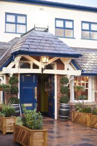 a house with a blue door and some plants at Governors House by Greene King Inns in Cheadle Hulme