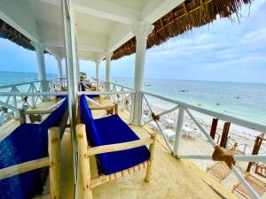 Equalia boutique hotel في جامبياني: منزل على الشاطئ مع الكراسي الزرقاء والمحيط