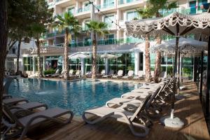 ein Schwimmbad mit Liegestühlen und ein Hotel in der Unterkunft Albanian Star Hotel in Golem