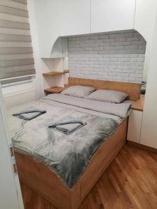 ein Schlafzimmer mit einem Bett mit zwei Kissen darauf in der Unterkunft Apartman Matija in Pale