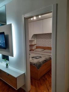 ein kleines Schlafzimmer mit einem Bett und einem TV in der Unterkunft Apartman Matija in Pale